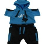 Blauwe knuffeloutfit met korte hoodie, Dino‑print en zwarte short met blauwe details op witte achtergrond.